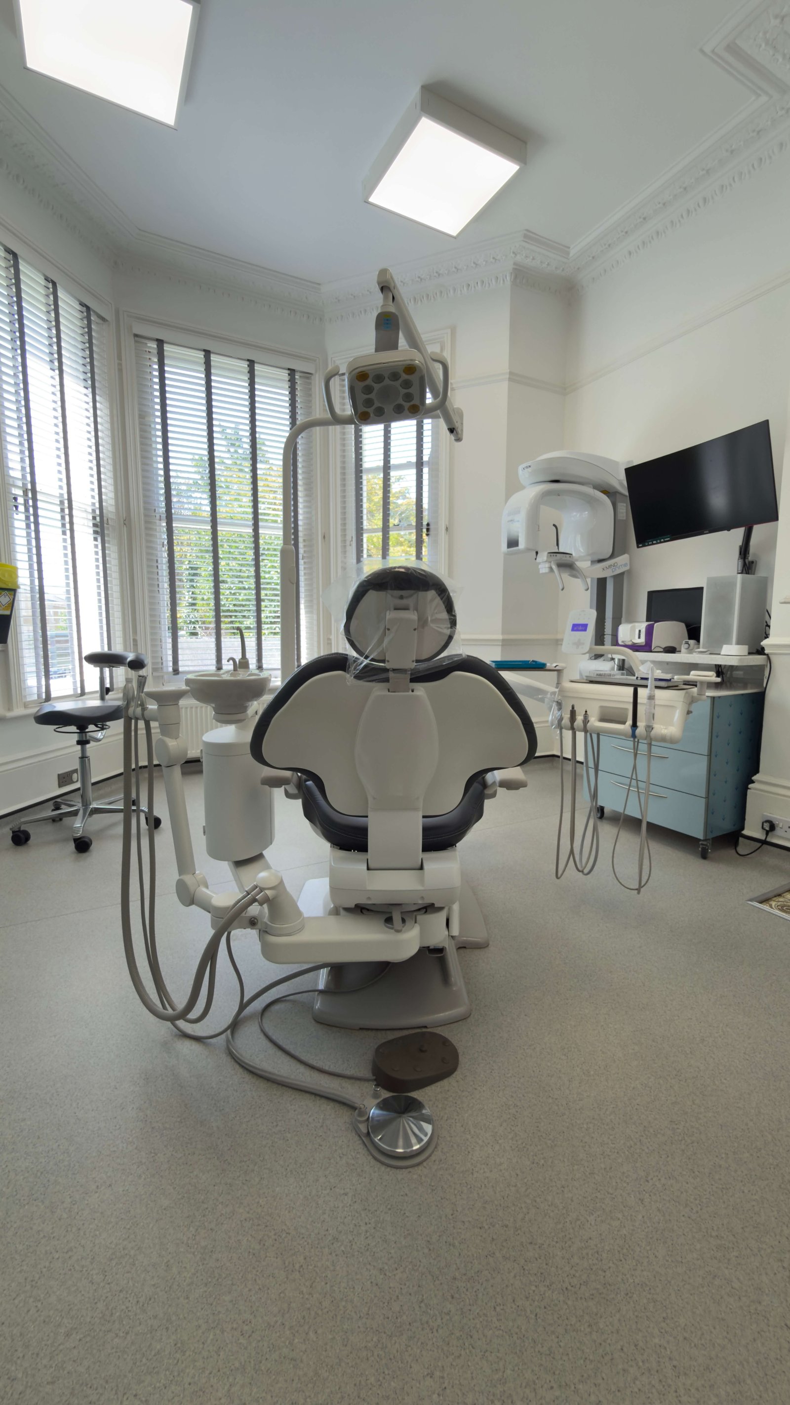 Modern treatment room with state-of-the-art dental chair and CBCT scanner