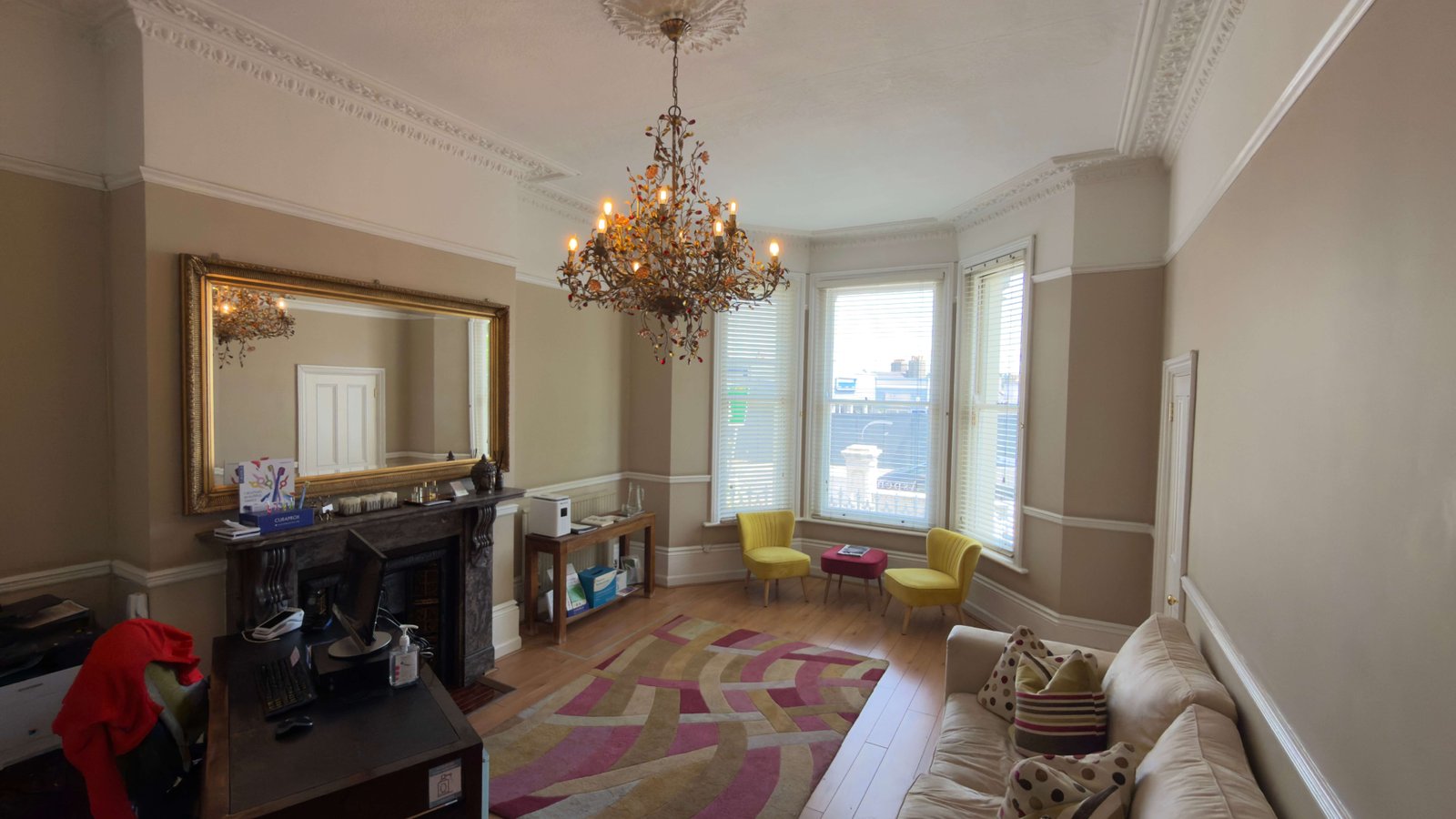 Elegant waiting room with chandelier, gilded mirror and bay windows